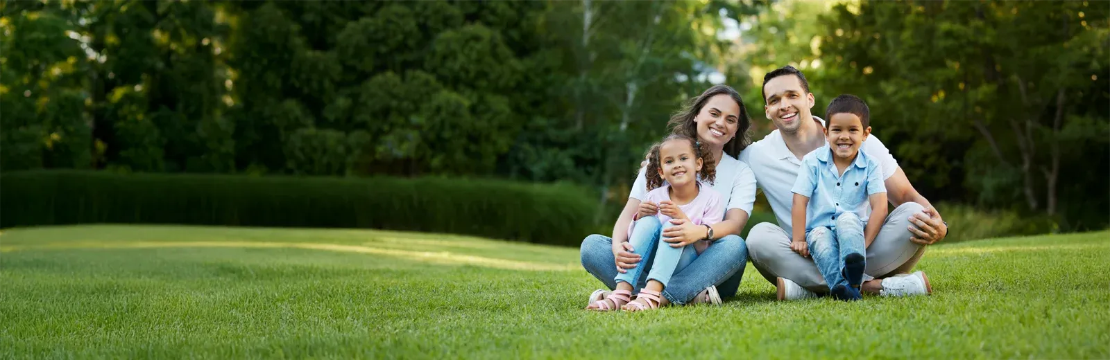 family sitting in back yard on grass